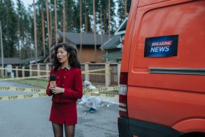 Female reporter in red outfit at an outdoor crime scene with warning tape and a news van. — Comment Banzai Slot construit une