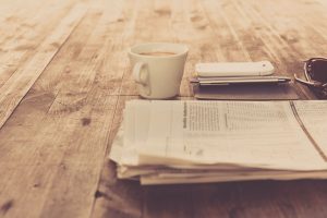 A warm vintage morning setup with coffee, newspaper, and smartphone on wooden table. — Golden Panda Casino Review: Snelle Win
