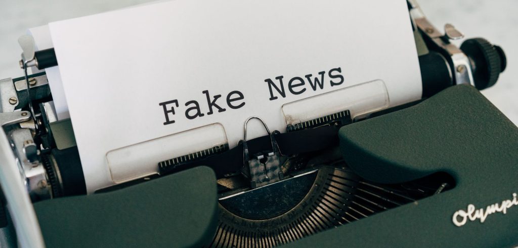 Close-up of vintage typewriter printing 'Fake News', depicting false information concepts. — Immersion dans le monde captivan