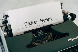 Close-up of vintage typewriter printing 'Fake News', depicting false information concepts. — Immersion dans le monde captivan