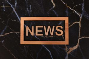 Wooden text of 'news' outlined on a dark, marbled surface, creating a striking contrast. — LuckyGem Casino und seine aktuelle