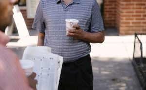 Crop anonymous ethnic male friends with coffee to go and newspaper speaking on city pavement — Mafia Casino : pourquoi se lan
