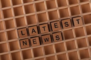 Wooden letter blocks spelling 'Latest News' on a grid surface. Ideal for media concepts. — Sensible Medical insurance Prepara