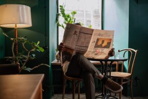 A man sits in a cozy café corner, enjoying a newspaper and relaxed ambiance. — Sind die Jackpot-Spiele im Turbo Winz Casino l