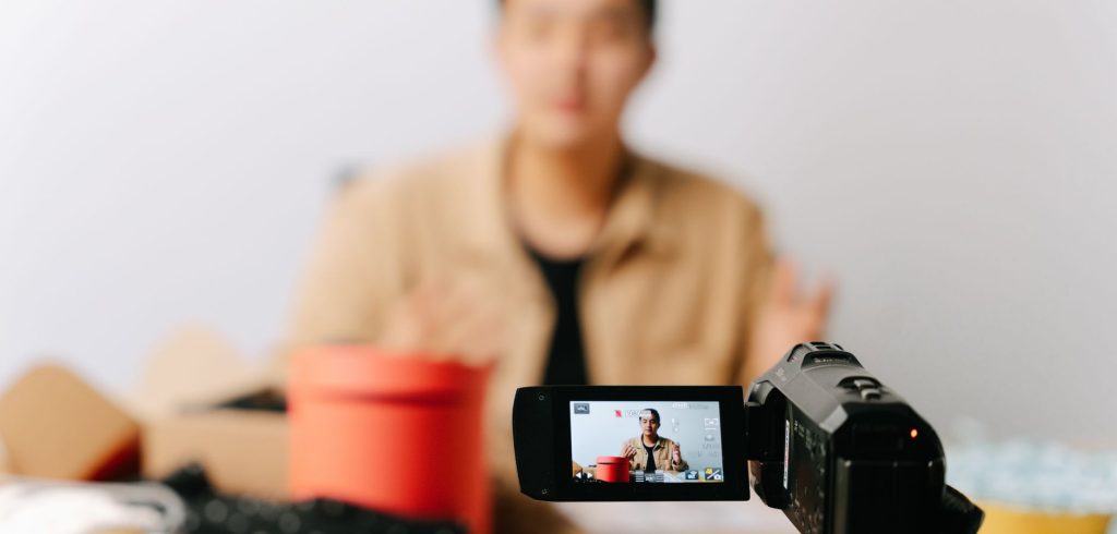 A blogger sits in front of a camera for filming a video indoors. — The Founding of YouTube A Short History
